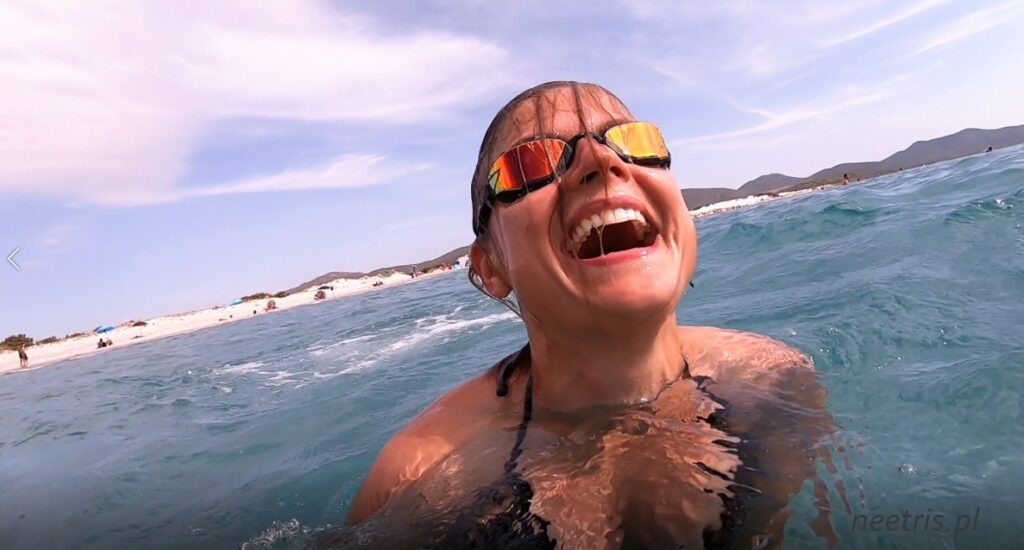 Zdjęcie przedstawiające radość - szeroki uśmiech autorki - neetris w morzu. Symbolizuje działanie neuronów lustrzanych poprzez udzielanie się pozytywnego nastroju innych osób